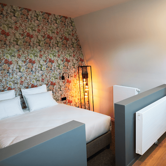 Une chambre avec un lit double et un décor fleuri